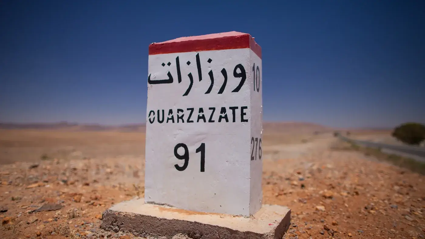 Milestone to Ouarzazate on a road out of Marrakech, the kind of trip where renting a car in Marrakech is worth it