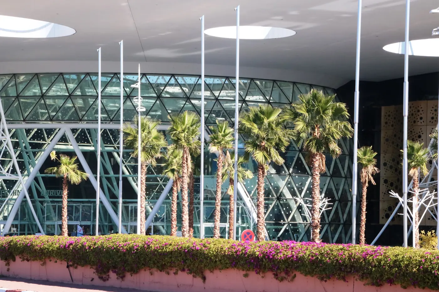 Aéroport Marrakech : façade vitrée et palmiers du terminal