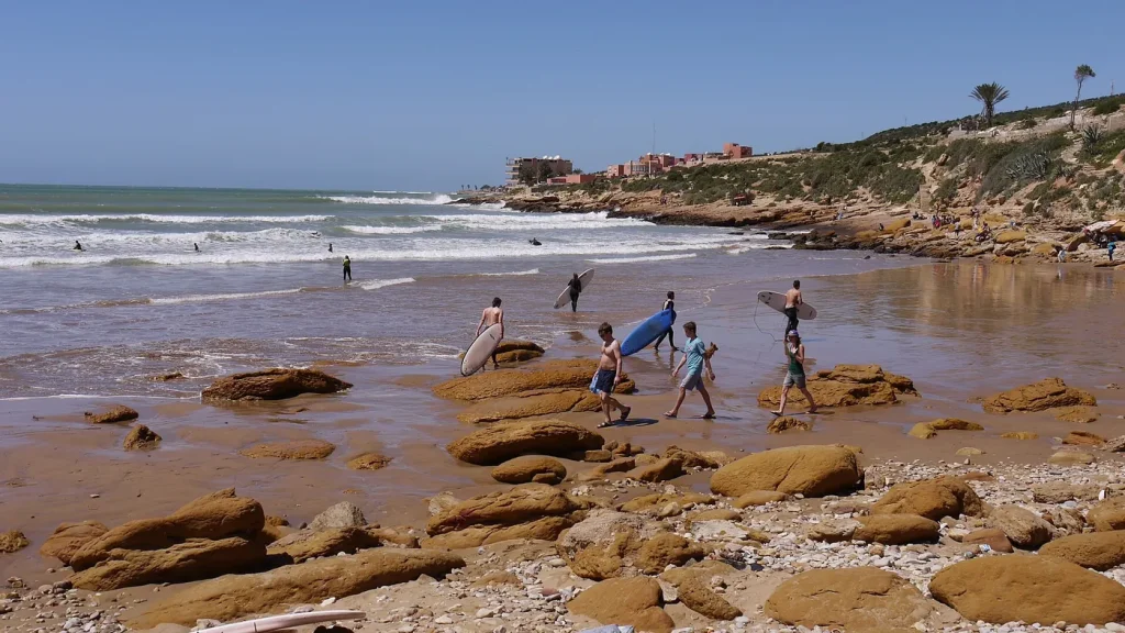 Taghazout: surfers on the rocky village beach